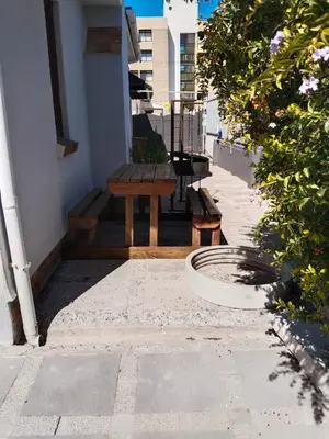 a wooden bench sitting on the side of a building at strand Holiday House in Strand