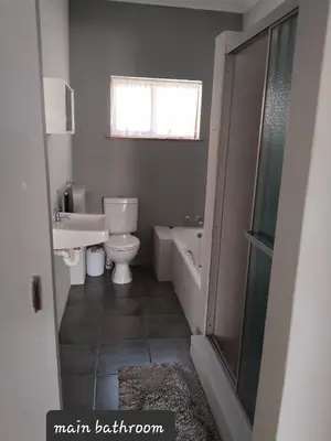 a bathroom with a toilet and a sink and a bath tub at strand Holiday House in Strand