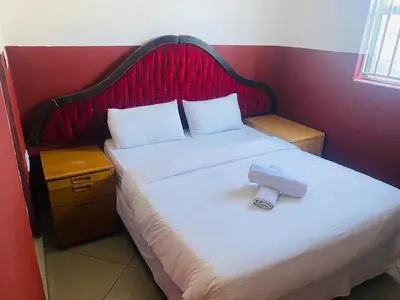 a bedroom with a bed with a camera on it at Prince Adina Guesthouse in Tiervlei