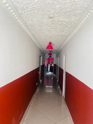 a hallway with red and white walls and a ceiling at Prince Adina Guesthouse in Tiervlei