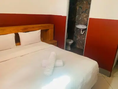 a bed with two rolls of toilet paper on it at Prince Adina Guesthouse in Tiervlei