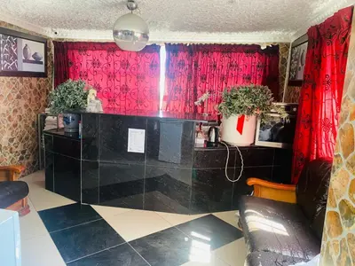 a living room with red curtains and a black counter at Prince Adina Guesthouse in Tiervlei