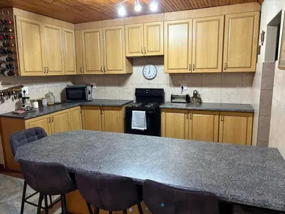a kitchen with a counter top and wooden cabinets at Waaigras in Brackenfell