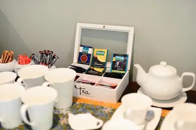 a table topped with white cups and a tea set at De Wingerd Wijnland Lodge in Paarl