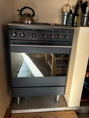 a black oven with a tea kettle on top of it at Peaceful coastal holiday home in Hermanus