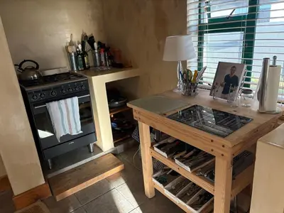 a kitchen with a wooden table and a stove at Peaceful coastal holiday home in Hermanus