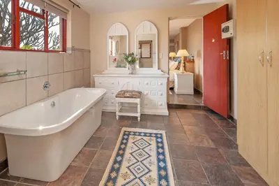 a bathroom with a tub and a sink at 18 On Kloof Guest House in Gordonʼs Bay