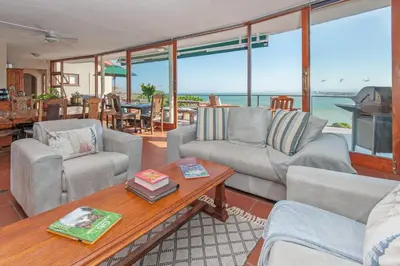 a living room with couches and a table at 18 On Kloof Guest House in Gordonʼs Bay