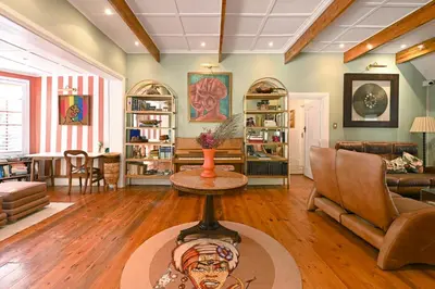a living room with a couch and a table at Mawethu on Mead Guesthome with Covered pool and Garden in Cape Town