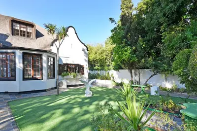 a garden in front of a house at Mawethu on Mead Guesthome with Covered pool and Garden in Cape Town