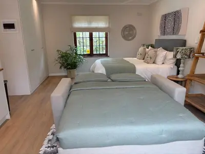 a living room with two beds and a couch at Protea Cottage Cozy & Private Studio in Claremont in Cape Town