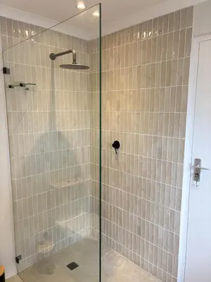 a shower with a glass door in a bathroom at Protea Cottage Cozy & Private Studio in Claremont in Cape Town