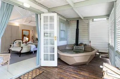 a bath tub in a room with a bedroom at Five Mountains Guest Farm & Spa in Wellington