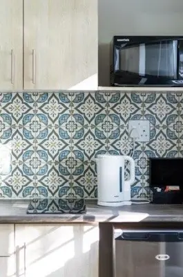 a kitchen counter with blue and white tile on the wall at Five Mountains Guest Farm & Spa in Wellington