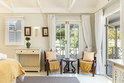 a bedroom with a bed and a table and chairs at Five Mountains Guest Farm & Spa in Wellington