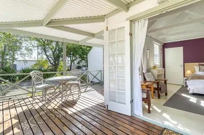 a screened in porch with a table and a bed at Five Mountains Guest Farm & Spa in Wellington