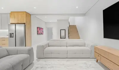a living room with a couch and a tv at Cape Signature Villa in Cape Town