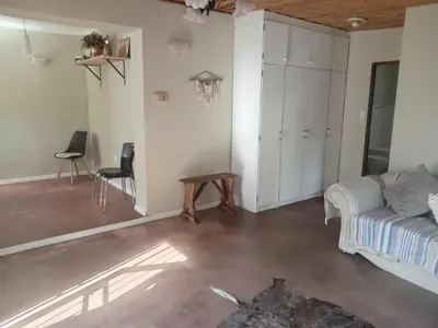 a living room with a bed and a table at Starfish Cottage in Kleinmond