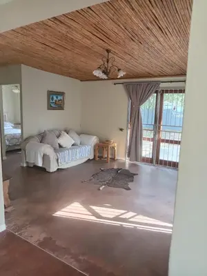 a bedroom with a bed in a room with windows at Starfish Cottage in Kleinmond