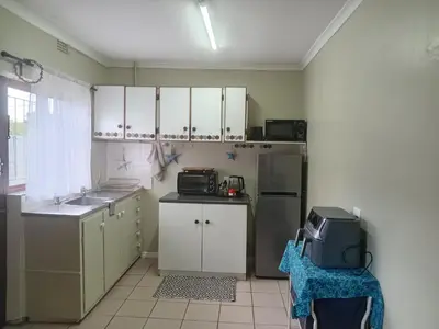 a small kitchen with a sink and a refrigerator at Starfish Cottage in Kleinmond
