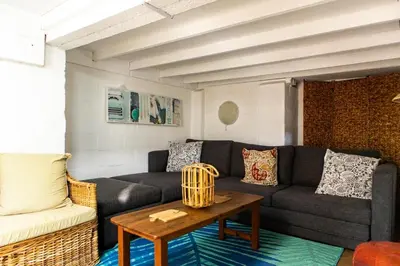 a living room with a couch and a table at Joan's Sea Cottage in Pringle Bay