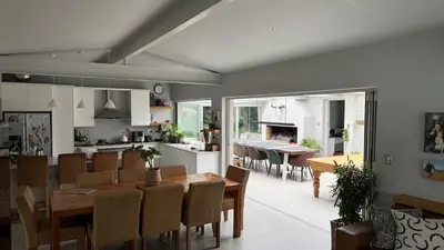 a dining room and kitchen with a table and chairs at Large and spacious family home is leafy suburb in Stellenbosch