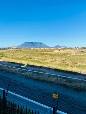 a road in the middle of a field with a fence at Opulent Home Stay in Cape Town