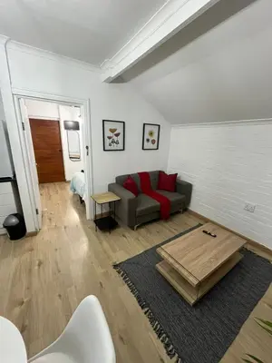 a living room with a couch and a table at Layover on Loerie in Cape Town
