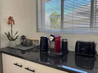 a kitchen counter with a coffee maker and a toaster at Layover on Loerie in Cape Town
