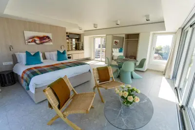 a hotel room with a bed and a table and chairs at Pringle Bay Beach Cottage in Pringle Bay