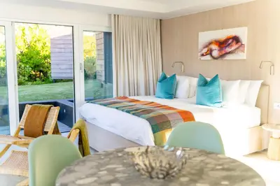 a hotel room with a bed and a balcony at Pringle Bay Beach Cottage in Pringle Bay