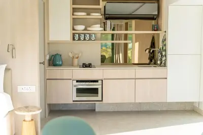 a kitchen with white cabinets and a stove top oven at Pringle Bay Beach Cottage in Pringle Bay