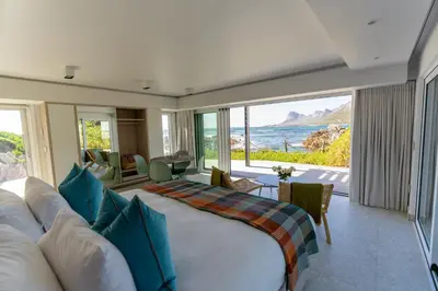 a living room with a couch and a view of the ocean at Pringle Bay Beach Cottage in Pringle Bay