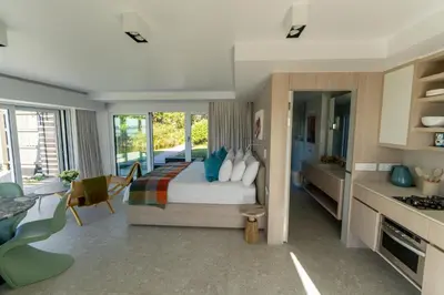 a bedroom with a bed with blue pillows at Pringle Bay Beach Cottage in Pringle Bay