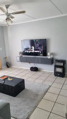 a living room with a flat screen tv on the wall at Riley's Place in Cape Town