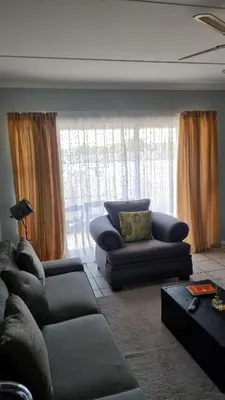 a living room with two couches and a large window at Riley's Place in Cape Town