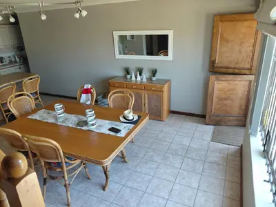 a kitchen and dining room with a table and chairs at HuisieBydieC in Hermanus
