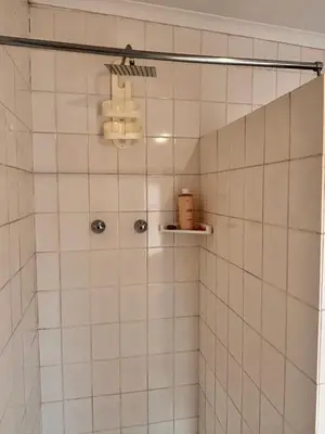 a bathroom with a shower with white tiles at Cape Comfy Hidden Home in Cravenby