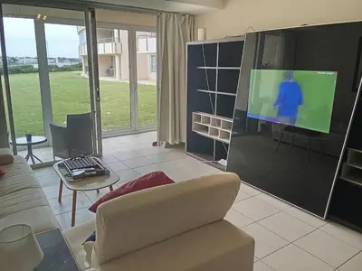 a living room with a couch and a flat screen tv at Spacious Beachfront 2bedroom apartment lagoon view in Cape Town