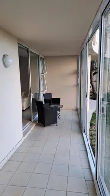 a balcony with chairs and tables in a building at Spacious Beachfront 2bedroom apartment lagoon view in Cape Town