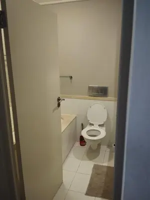 a bathroom with a white toilet and a sink at Spacious Beachfront 2bedroom apartment lagoon view in Cape Town