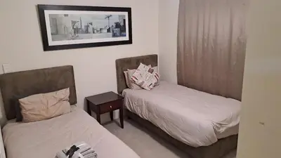 a room with two beds and a picture on the wall at Spacious Beachfront 2bedroom apartment lagoon view in Cape Town