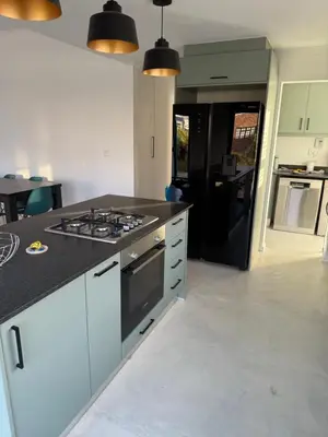 a kitchen with a stove and a black refrigerator at Mountain View 2-Bedroom Home Near the Beach in Pringle Bay in Pringle Bay