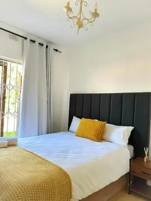 a bed with a black headboard in a bedroom at Lux City Haven in Cape Town