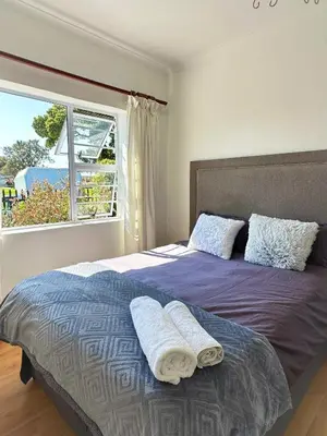 a bedroom with a bed with two towels on it at Lux City Haven in Cape Town
