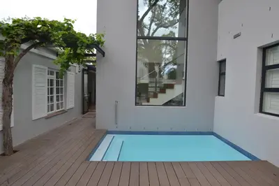 a swimming pool in the courtyard of a house at Just Joey Lodge in Stellenbosch