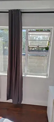 a window with a brown curtain in a room at MAREE LODGe GUEST HOUSE BELLEVILLE in Bellville