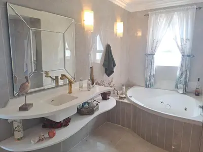 a bathroom with a sink and a tub and a mirror at Boutique Inn - Serenity in Gordonʼs Bay
