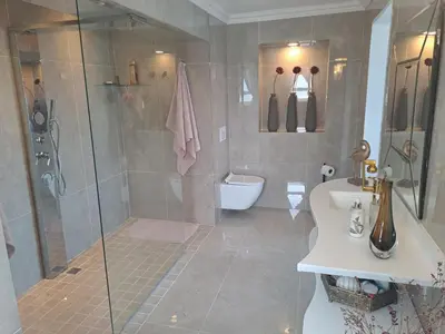 a bathroom with a shower and a toilet and a sink at Boutique Inn - Serenity in Gordonʼs Bay