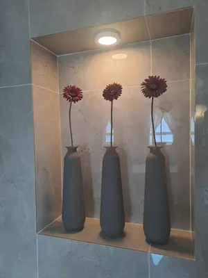 two vases with flowers in them on a shelf at Boutique Inn - Serenity in Gordonʼs Bay